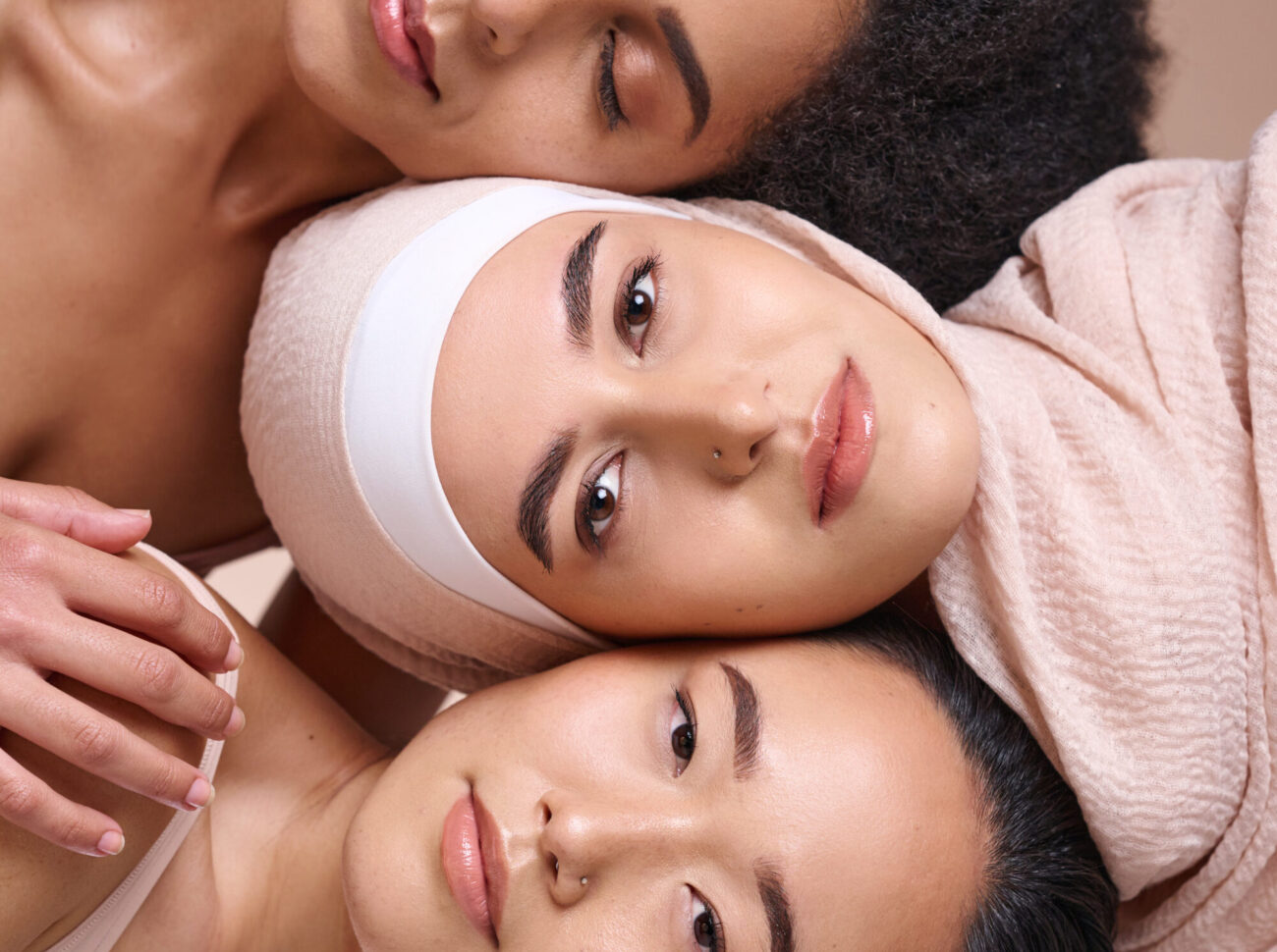 Portrait, beauty and diversity with woman friends in studio on a brown background for skincare or i.